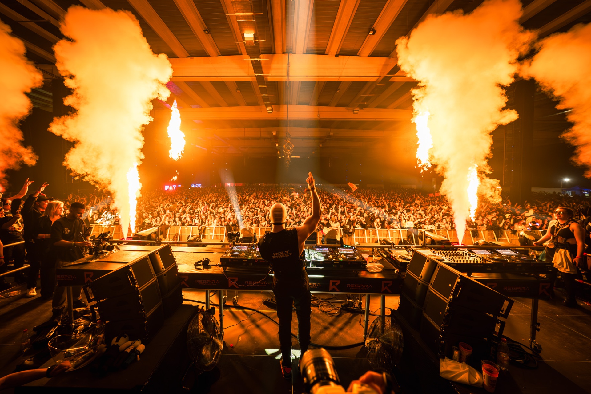 Vista desde escenario con DJ y llamaradas