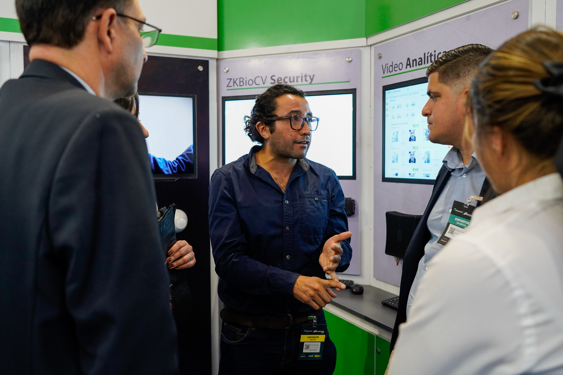 Persona explicando soluciones tecnológicas a visitantes dentro del stand